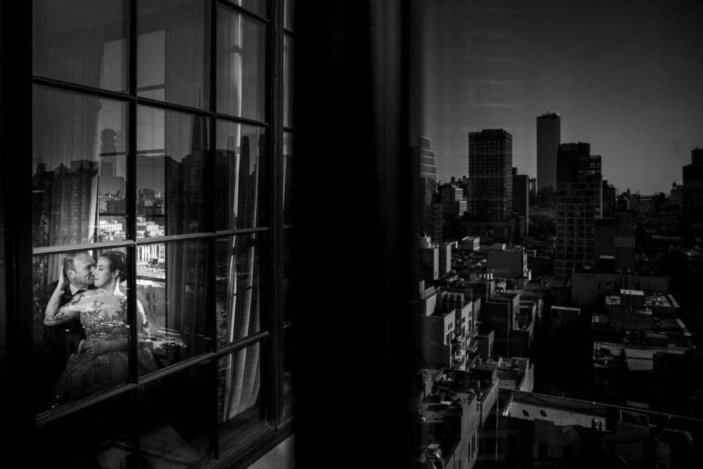 A black and white photo of a couple during their elopement out of a NYC window.