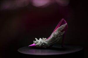 A pink high heeled shoe on a black background, perfect for a wedding.