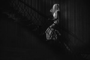 A black and white photo of a woman on a staircase at a wedding event.