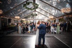 A couple's first dance at their wedding reception, held inside a tent.