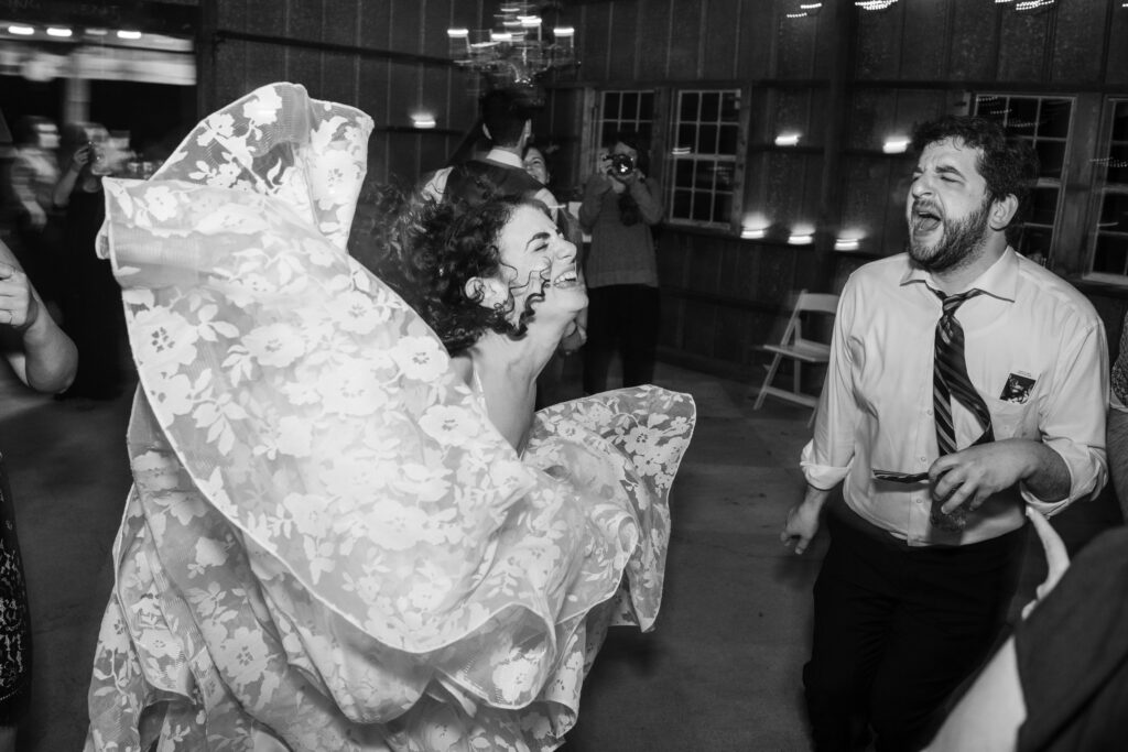 A bride and friend dancing at a wedding.