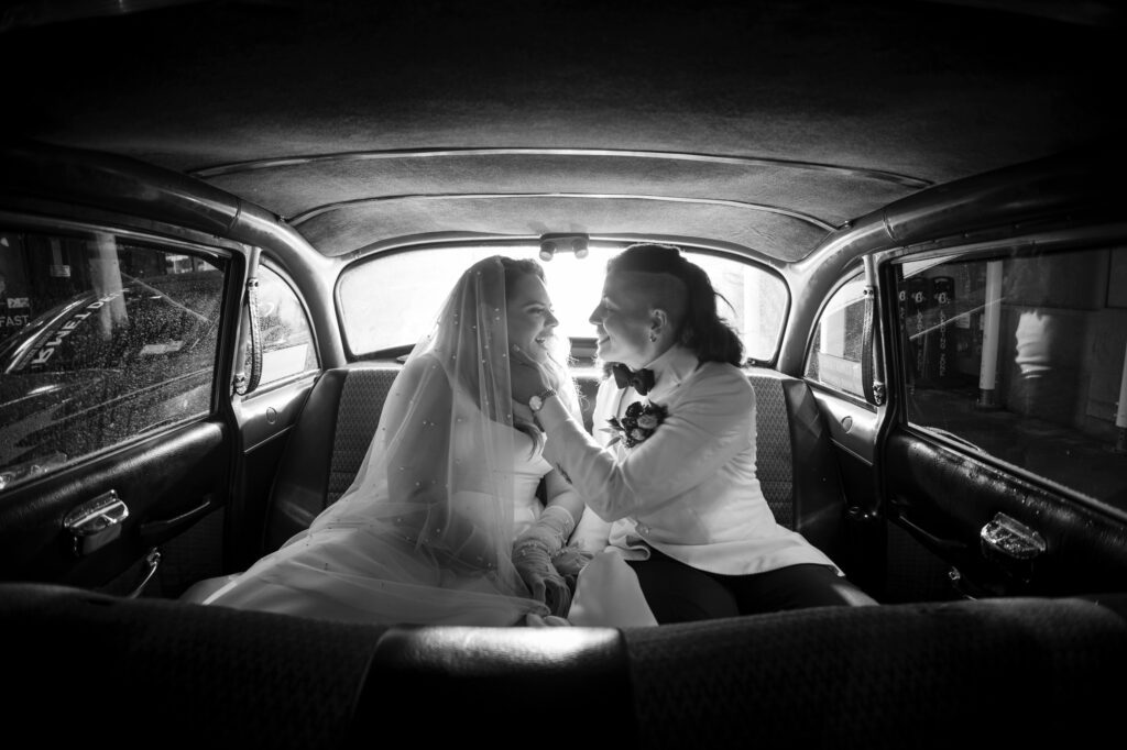 Newlyweds share a passionate kiss in the back seat of a car after their wedding at the elegant Beekman Hotel in New York.