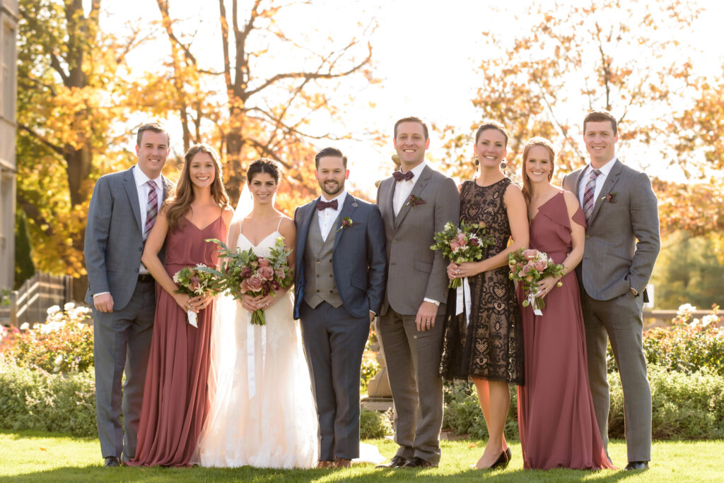 A group of bridesmaids and groomsmen posing for a photo at Sands Point Preserve wedding.