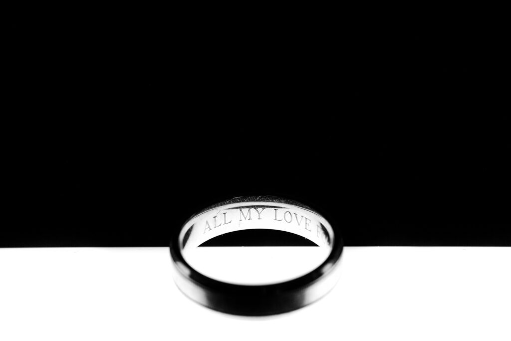 A black and white photo of a wedding ring.