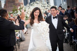 A bride and groom walk down the aisle at a Tribeca Rooftop wedding ceremony.