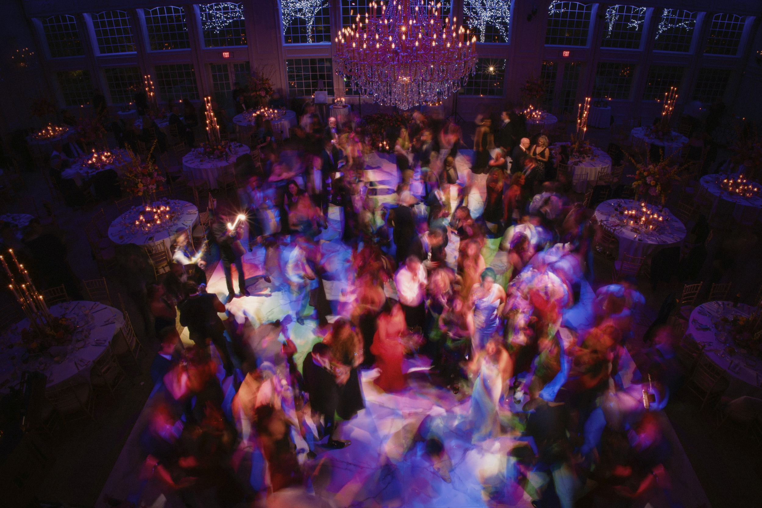 A blurry image of people dancing at an Estate at Florentine Gardens wedding in a ballroom.