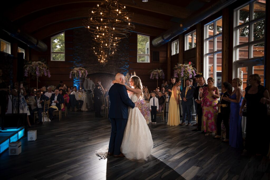 A bride and groom sharing their first dance at the Stone House at Stirling Ridge wedding venue, in a large room.