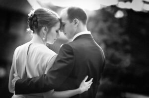 A black and white photo of a wedding couple hugging at Stone House at Stirling Ridge.