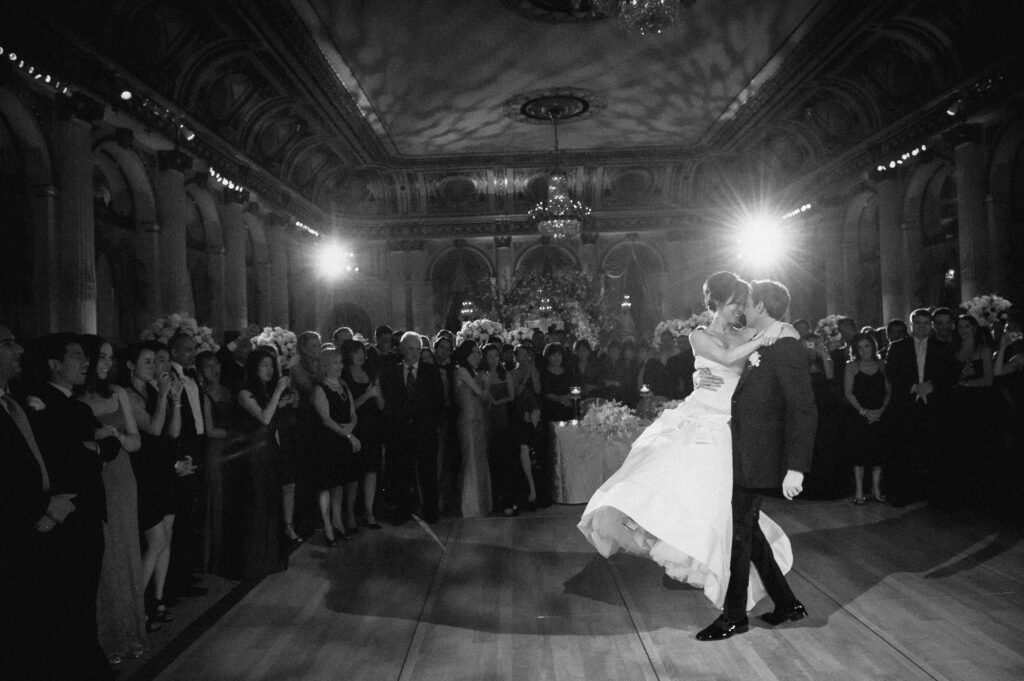 A wedding with the bride and groom sharing their first dance in a large ballroom at Plaza Hotel.