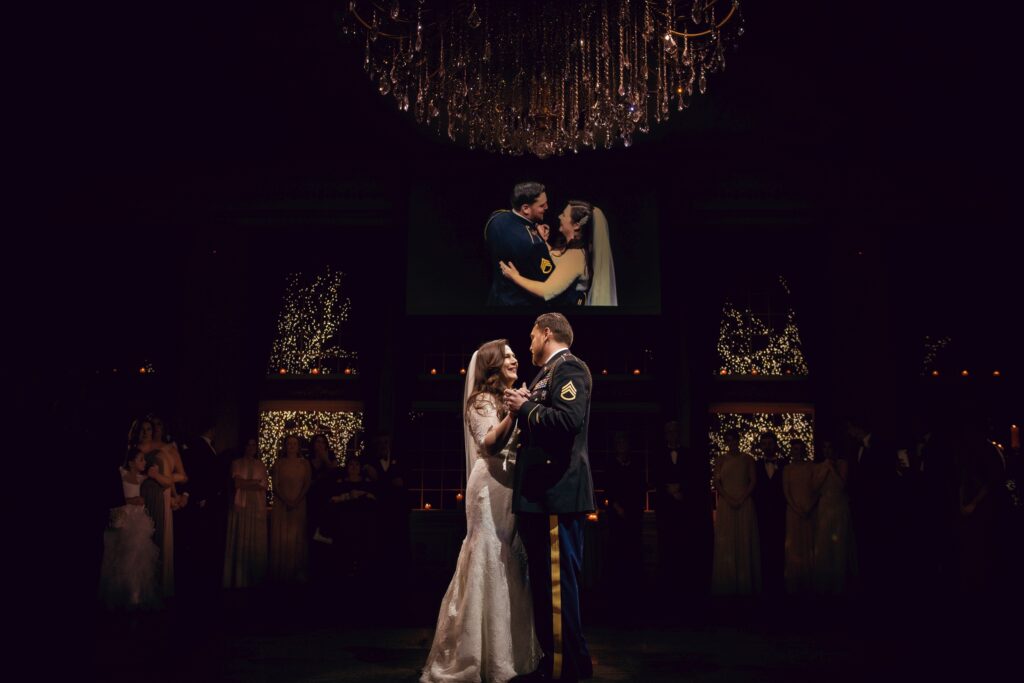A bride and groom share their first dance at an Estate at Florentine Gardens wedding, elegantly illuminated by a chandelier.