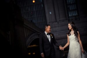A man and woman holding hands during their intimate portrait session at Cipriani for their wedding.