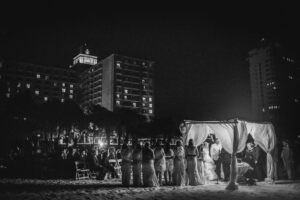 A black and white photo of a destination wedding ceremony at night.
