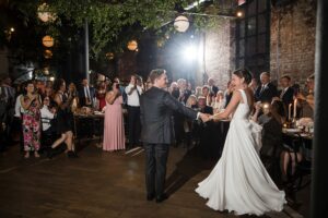 A bride and groom sharing their first dance at a Wythe Hotel wedding reception.