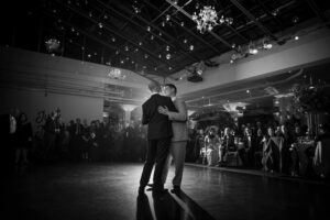 A black and white photo of two grooms sharing their first dance at a Tribeca Rooftop wedding.