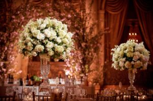 A wedding reception at Plaza Hotel decorated with white flowers in vases.
