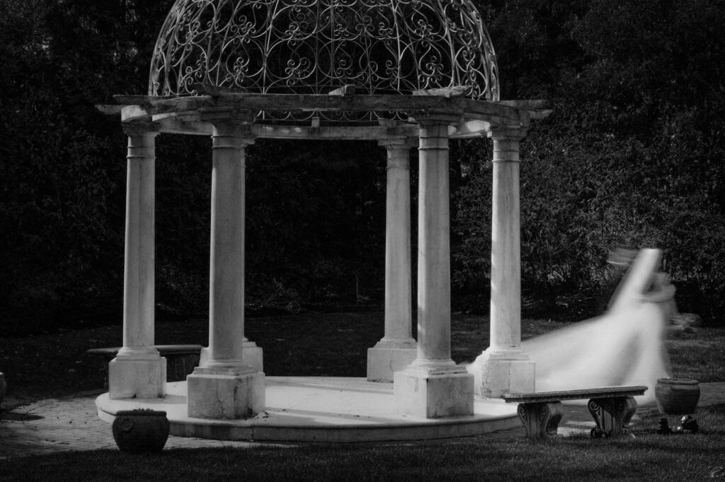 A black and white photo of a bride in a gazebo at an Estate at Florentine Gardens wedding.