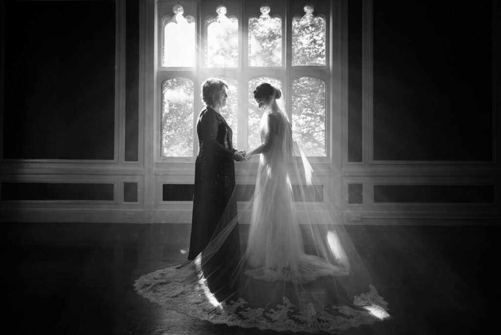 A Sands Point Preserve wedding with a bride and her mom standing in front of a window.