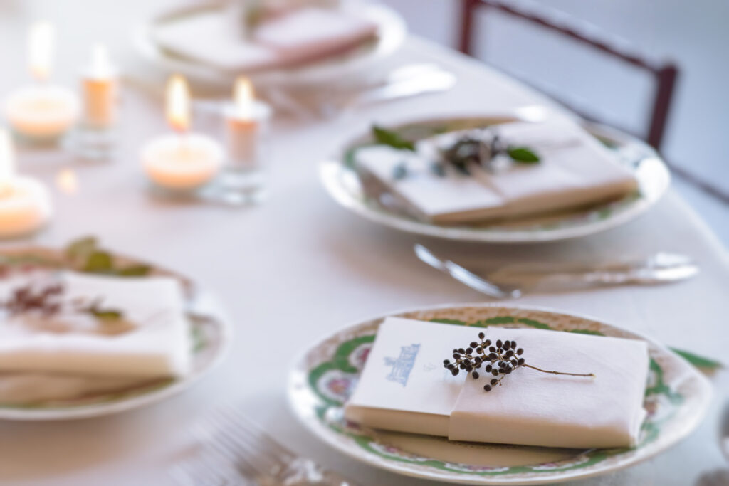 A white plate with a napkin on it, placed on a wedding reception table at Sands Point Preserve's Hempstead House.
