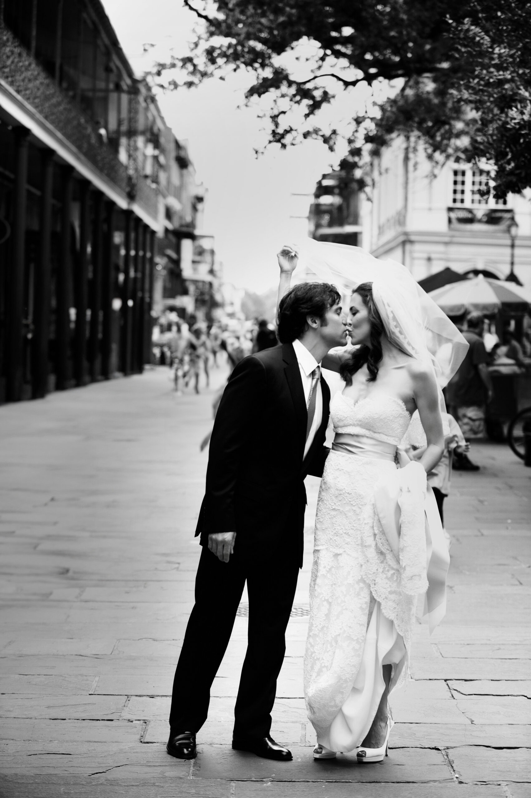 A bride and groom share a kiss on a street in New Orleans for their destination wedding.