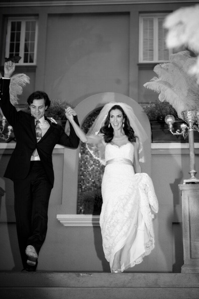 Black and white photo of bride and groom descending steps during a New Orleans destination wedding.