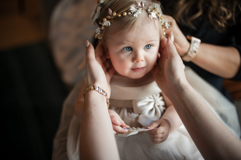 A baby girl is wearing a flower crown at a Modernhaus wedding.