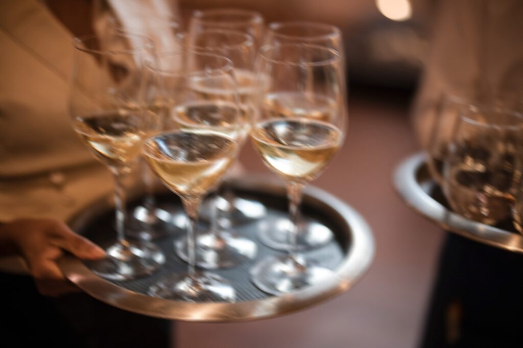 At a Twenty-Three Grand Modernhaus Soho wedding, a waiter elegantly holds a tray of champagne glasses.