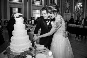 A Hotel duPont wedding where the bride and groom are cutting into a beautiful wedding cake.