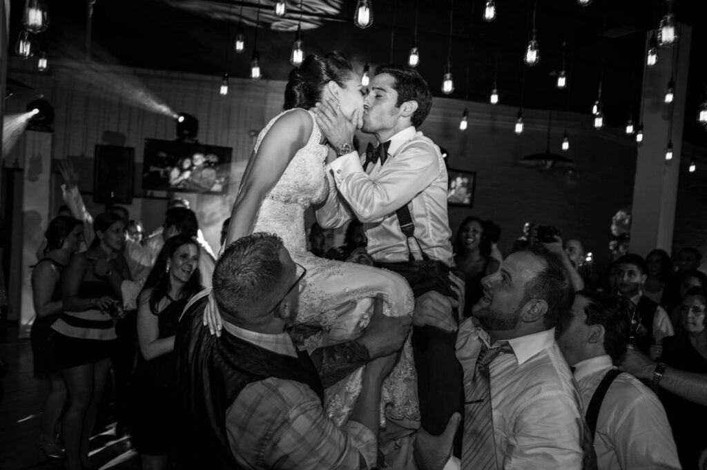 A bride and groom sharing a passionate kiss on the dance floor at their Liberty Warehouse wedding.