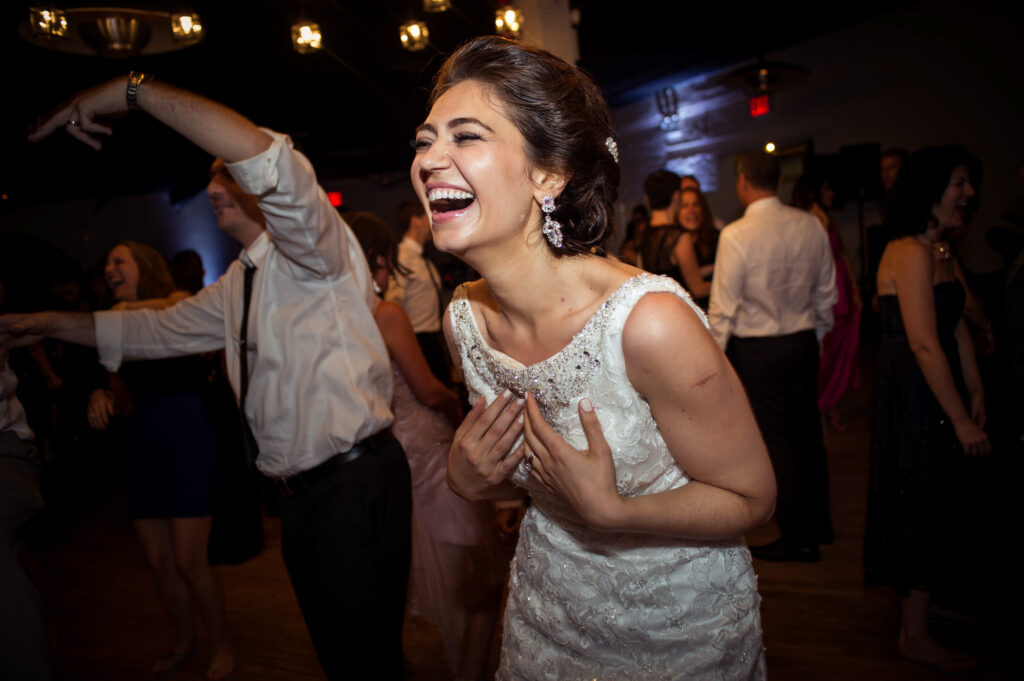 a bride dances in a white dress at her liberty warehouse wedding reception