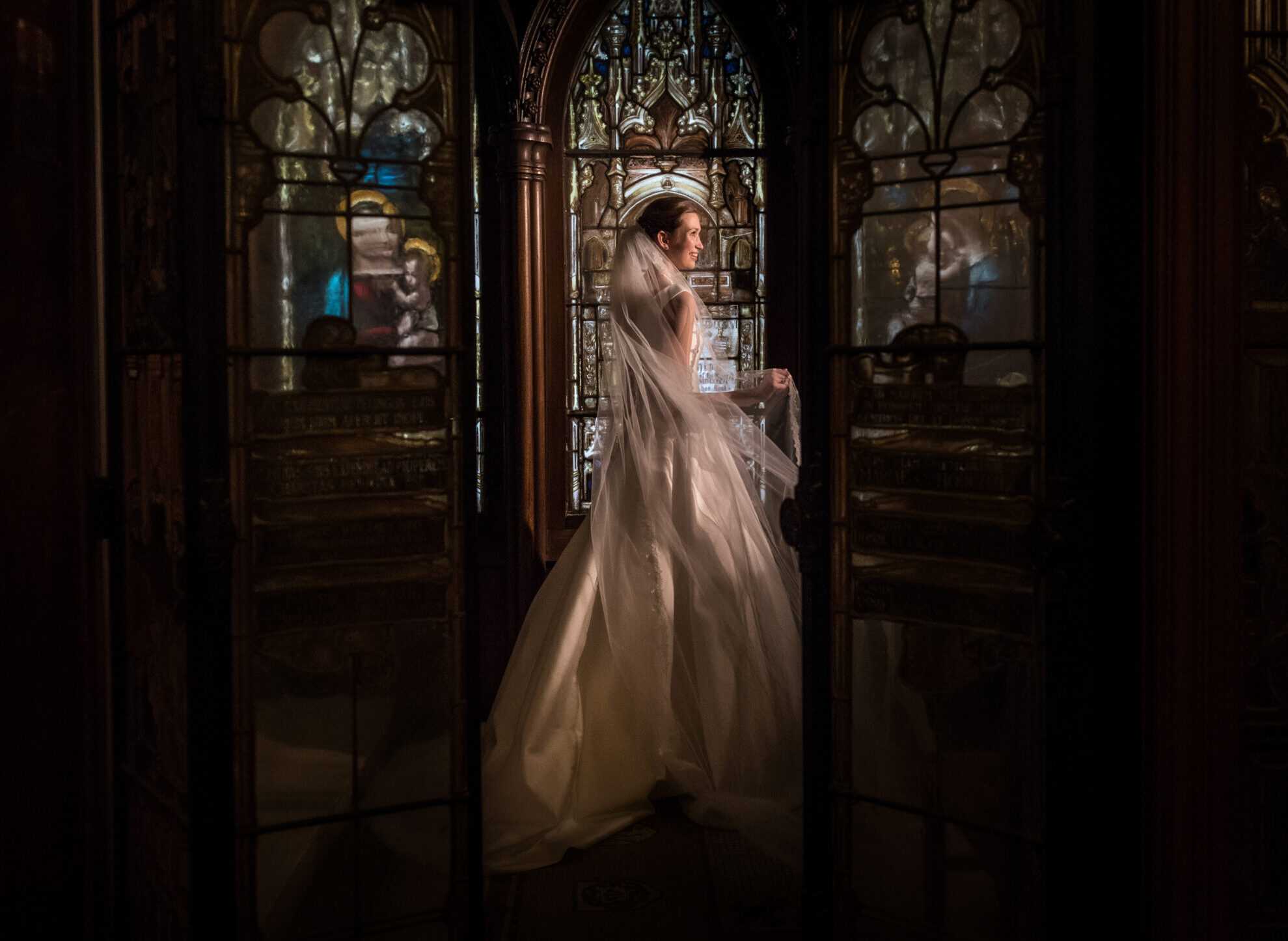 bride posing against the stained glass windows of a church
