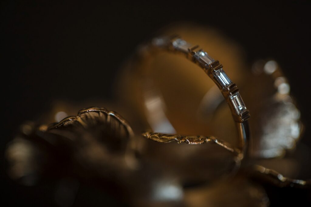 Close-up of an elegant ring with clear gemstones on an intricate gold setting, captured at a Stonover Farm Wedding.