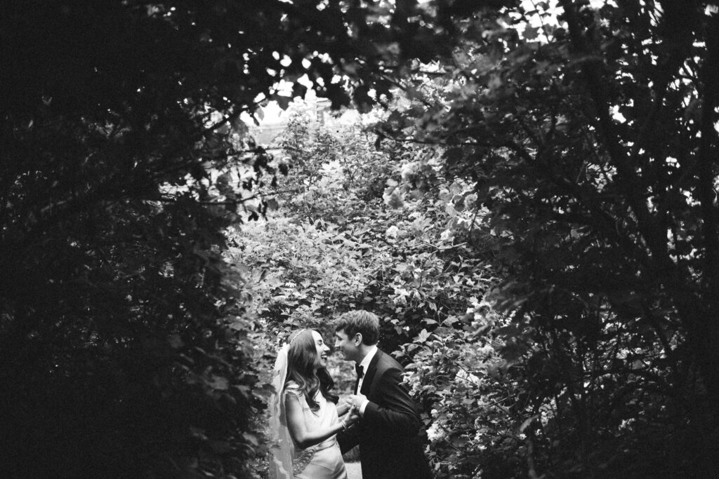 Two people sharing an intimate moment amidst lush foliage during their Hudson Valley Wedding at The Hill.