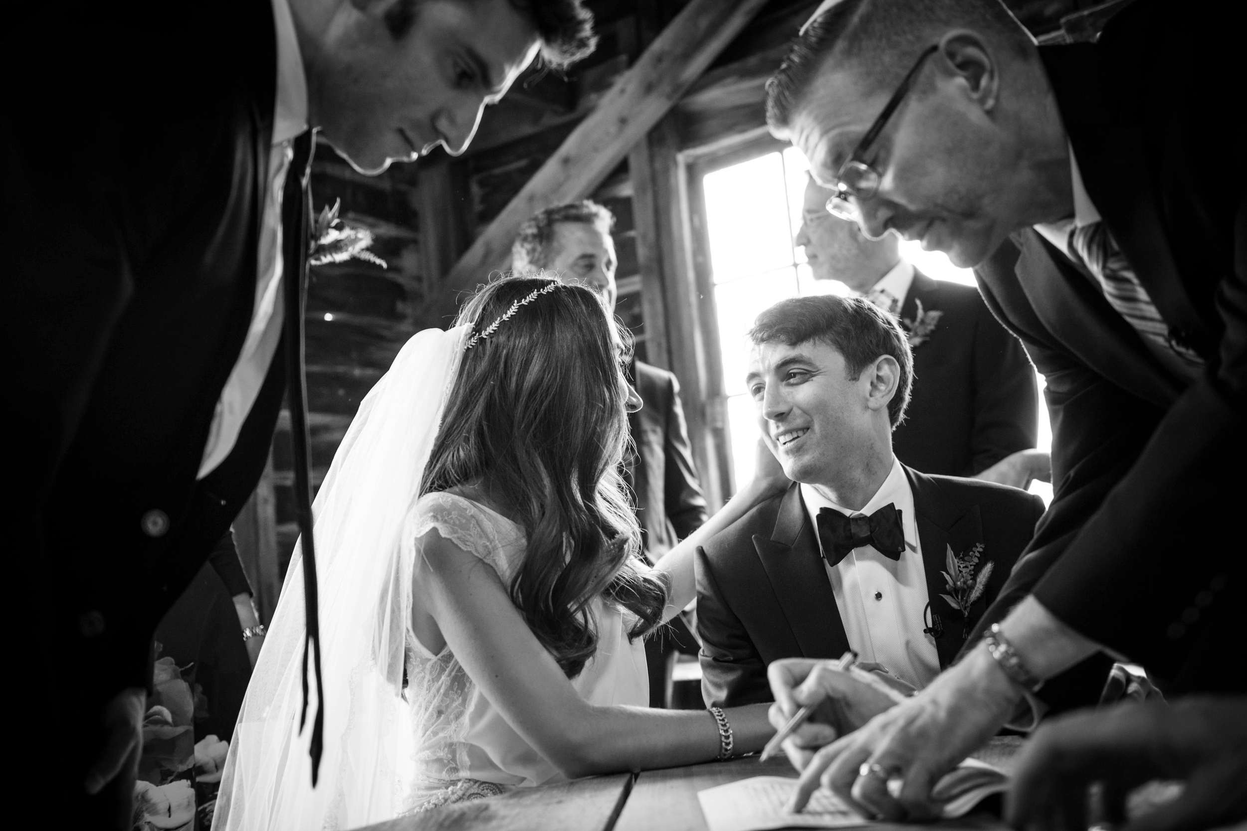 Bride and groom signing their ketubah at Hudson Valley Weddings at The Hill while witnesses look on. Bride and groom signing their ketubah at Hudson Valley Weddings at The Hill while witnesses look on.