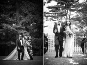 A black and white photo from Hudson Valley Weddings at The Hill depicts a joyful bridal party walking outdoors, with the bride and groom leading the way, smiling.