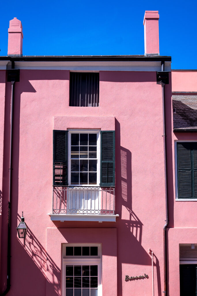 A pink building with a balcony in New Orleans.