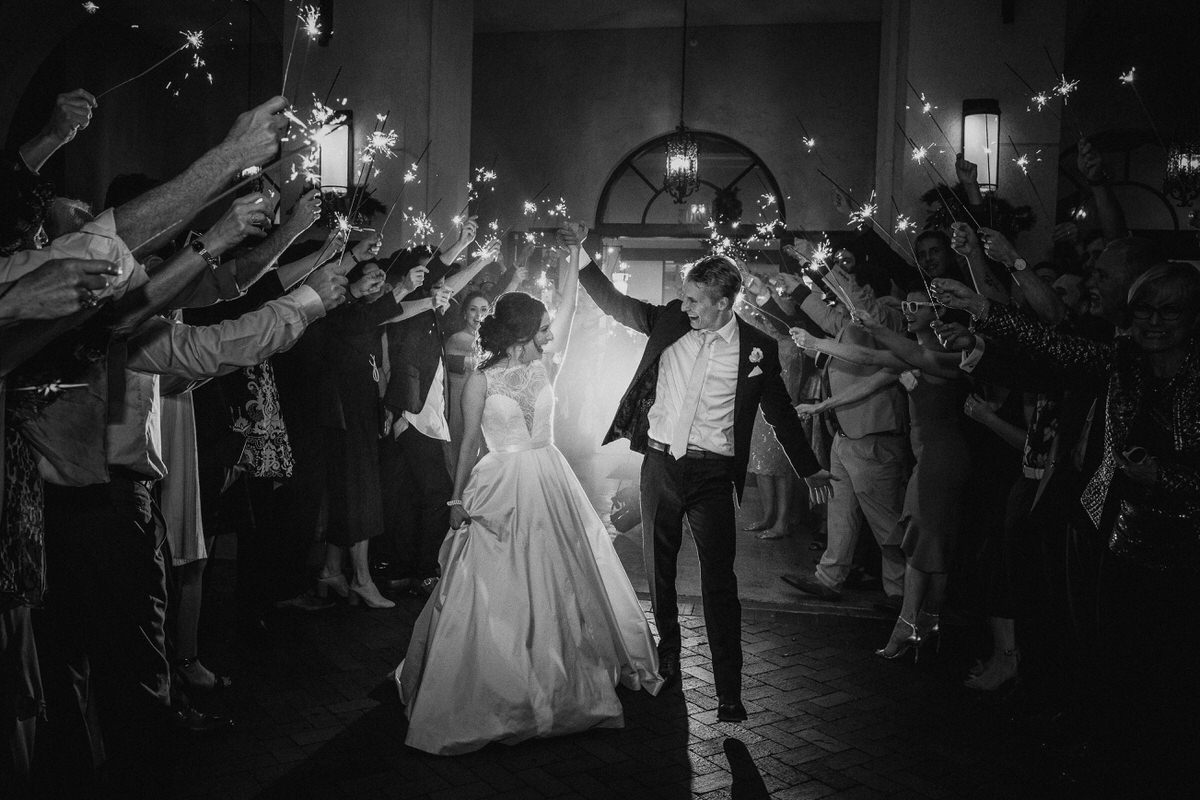 Newlyweds make a grand exit through a tunnel of guests holding sparklers
