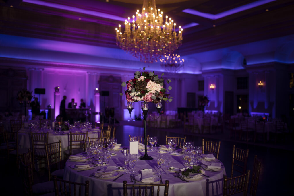 Elegant Park Chateau wedding banquet hall setup with floral centerpiece and ambient purple lighting.