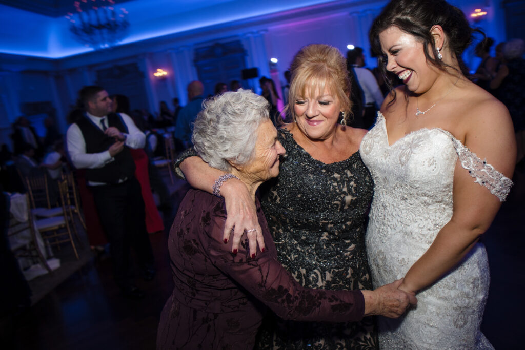 Three generations of women share a joyful moment at a Park Chateau wedding reception.