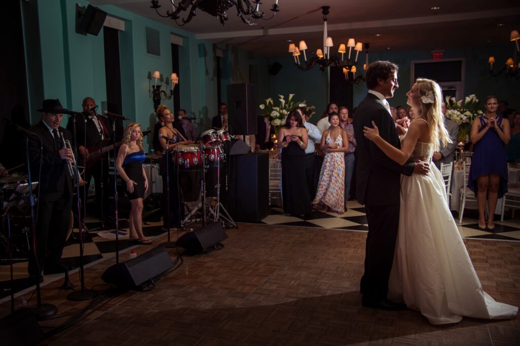 A bride and groom dance closely while a live band performs in the background at a Congress Hall Cape May wedding reception.