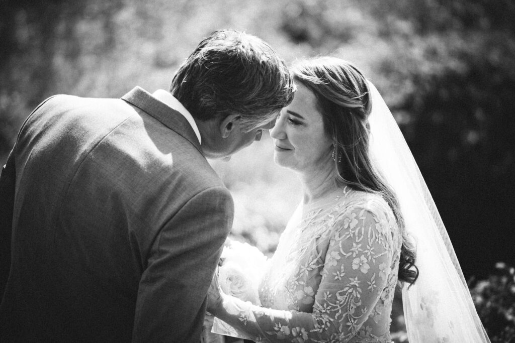 A bride and groom share a tender moment during their ocean house Rhode Island wedding day.