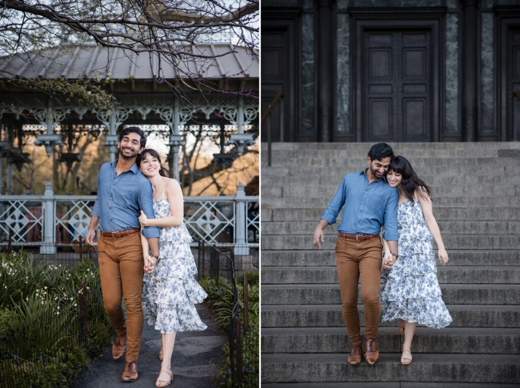 A couple in matching blue shirts and brown pants walks happily together in Central Park, engaging in a joyful photoshoot near the grand stairs outside a beautiful building.