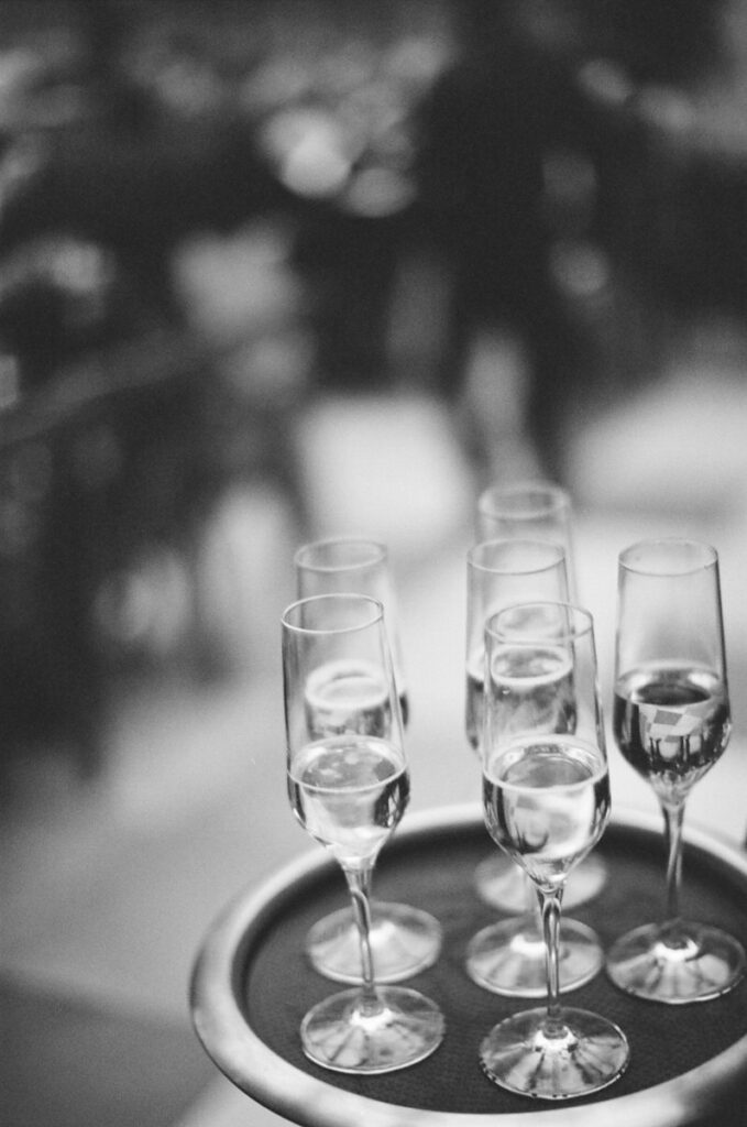 A film wedding photo of champagne glasses on a tray