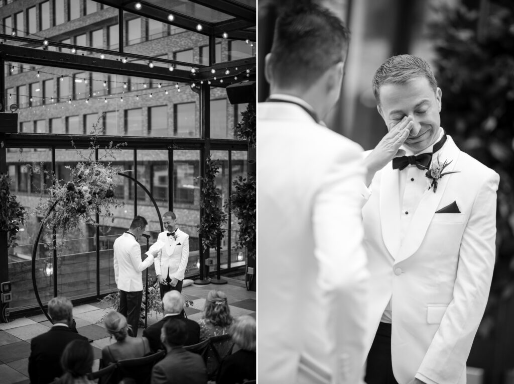 The couple at the altar, exchanging vows under a floral arch at their 74 Wythe rooftop wedding, one partner gently wiping away tears in a touching moment.