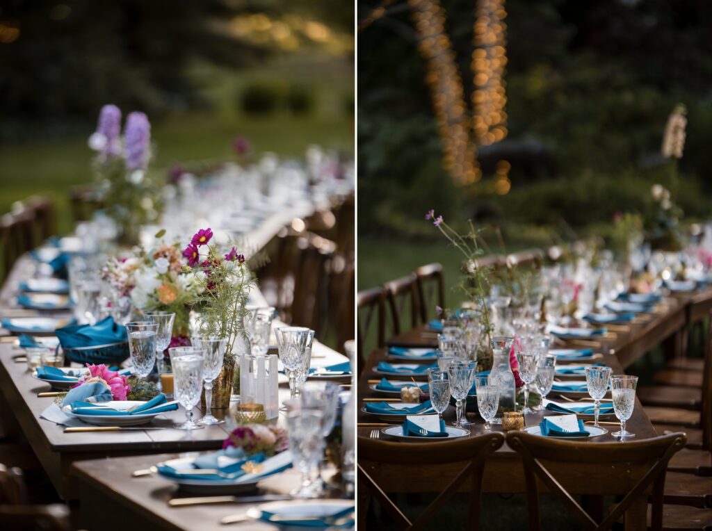 An outdoor dining table set for a Nestldown wedding event with floral arrangements, glassware, blue napkins, and golden flatware. The table is decorated with string lights in the background.