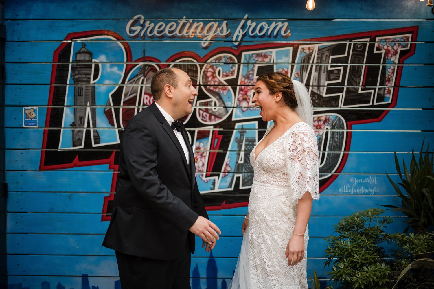 Bride and groom by mural 'greetings from Roosevelt Island' at the Sanctuary NYC wedding.
