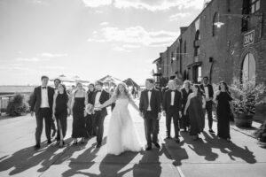 A bride and groom walk with their wedding party.