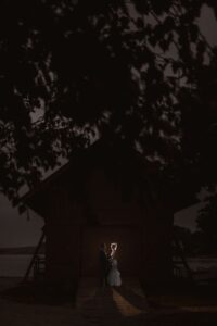 A couple stands illuminated in the doorway