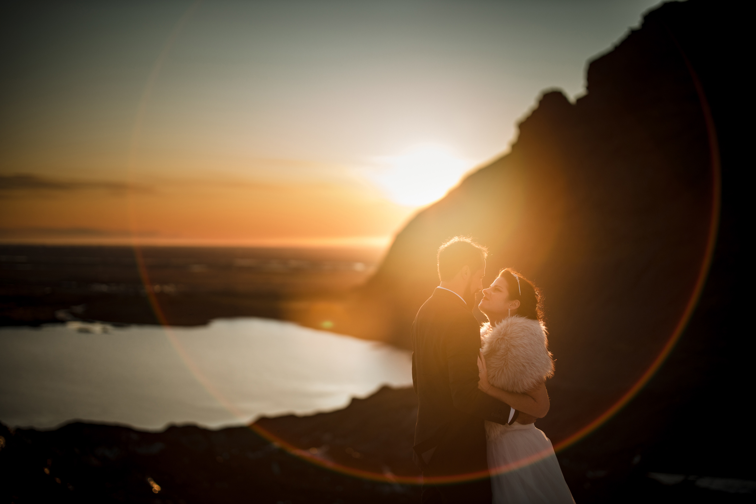 newlywed couple posing during sunset in mountains