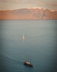 A sailboat during sunset creating beautiful views for destination weddings in Santorini