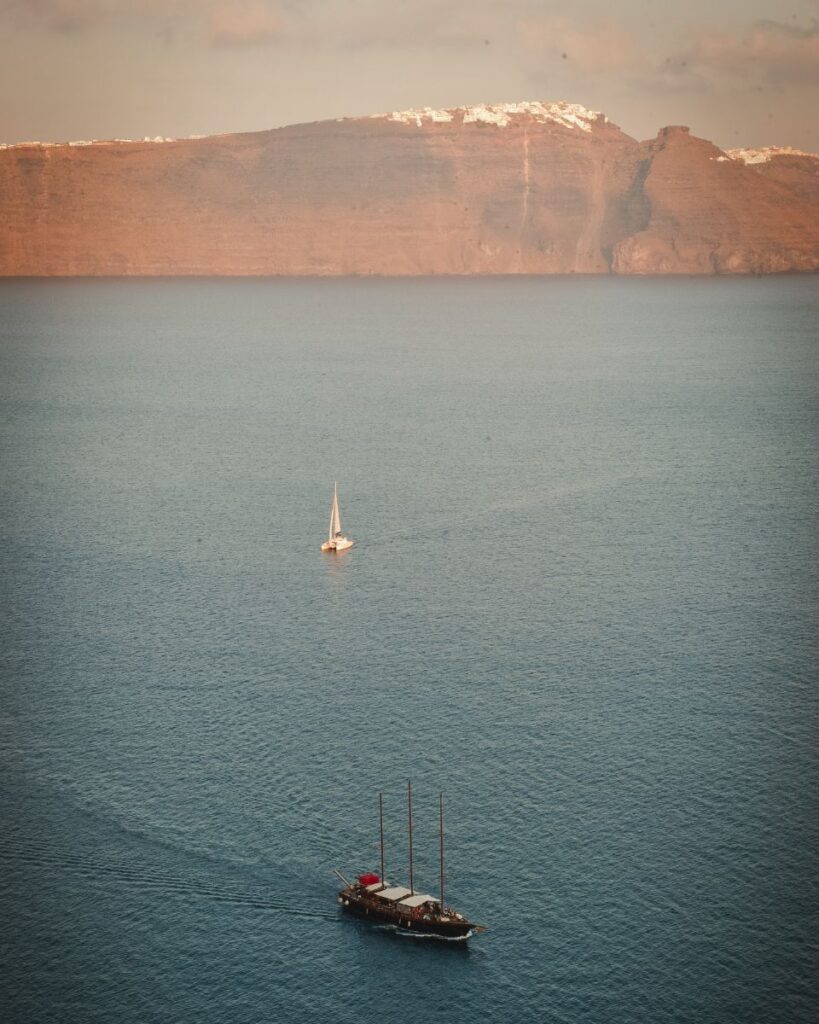 A sailboat during sunset creating beautiful views for destination weddings in Santorini